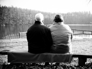 zwei menschen auf einer bank am see